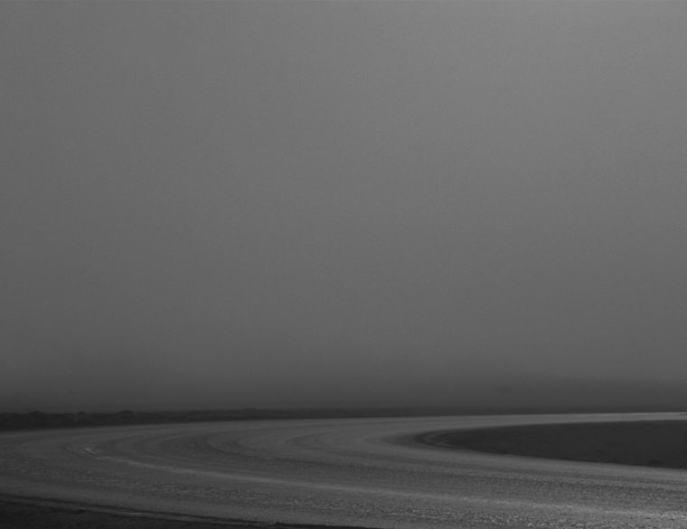 An empty road curving into fog